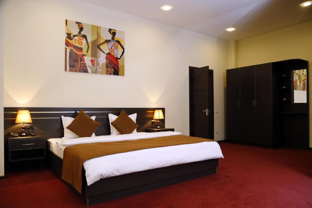 Un pat sau paturi într-o cameră la Tomu's Hotel