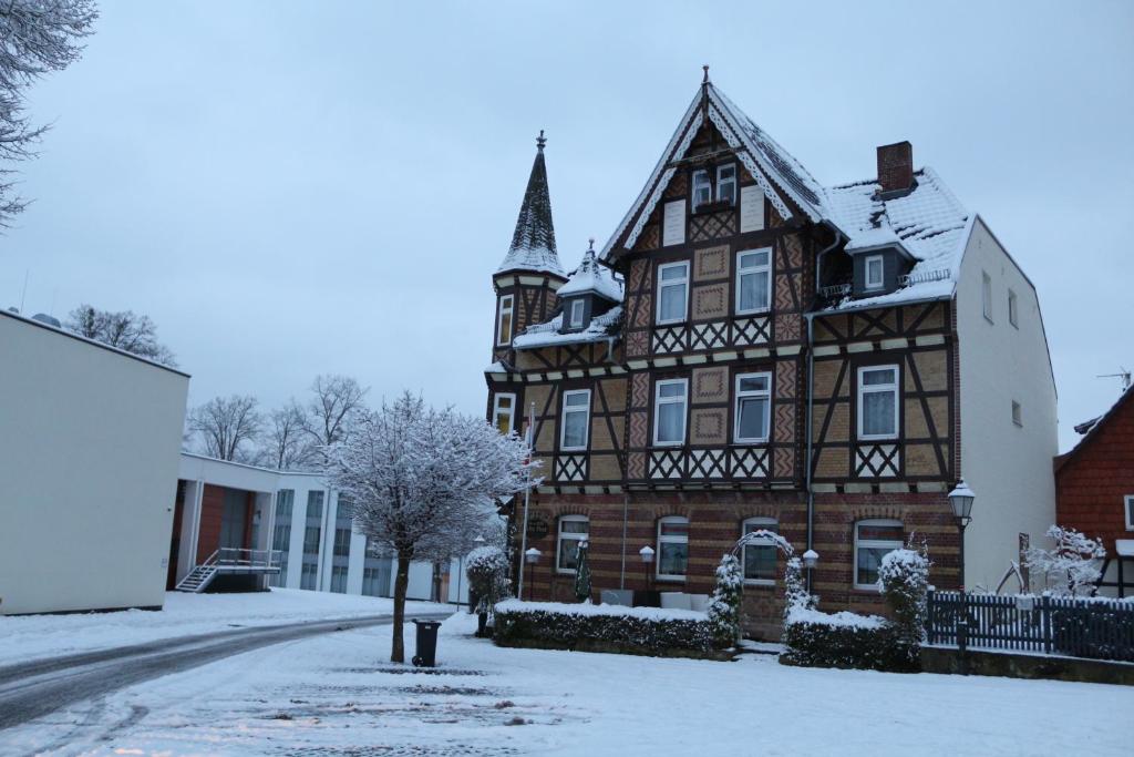 een oud gebouw met sneeuw op de grond bij Hotel Alte Post in Bad Sooden-Allendorf