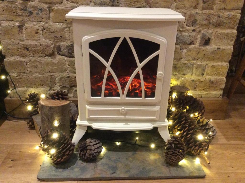 a white fireplace with christmas lights in a room at Passengers House in Whitstable