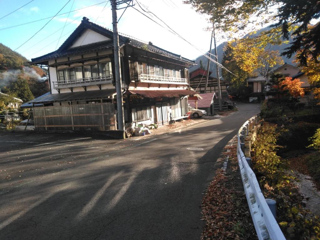 un antiguo edificio al lado de una carretera en Minpaku Sarai Nikkoya, en Okkia