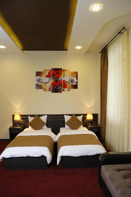 Postel nebo postele na pokoji v ubytování Tomu's Hotel