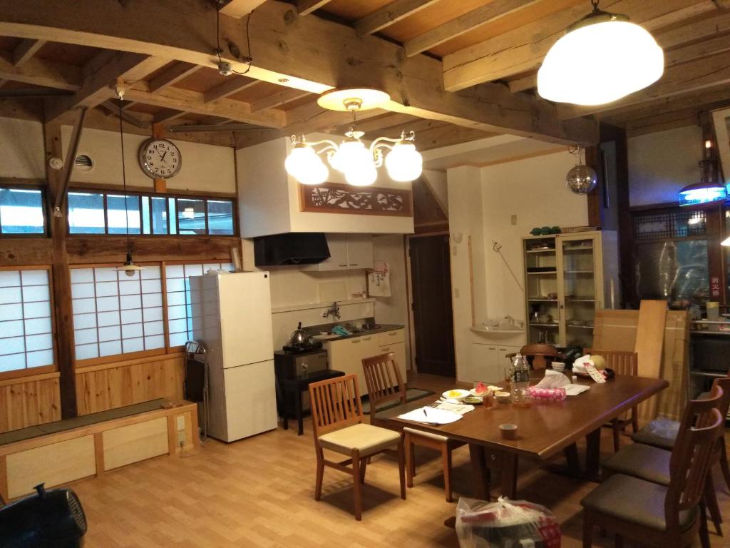 a kitchen and a dining room with a table and chairs at Minpaku Sarai Nikkoya in Okkia