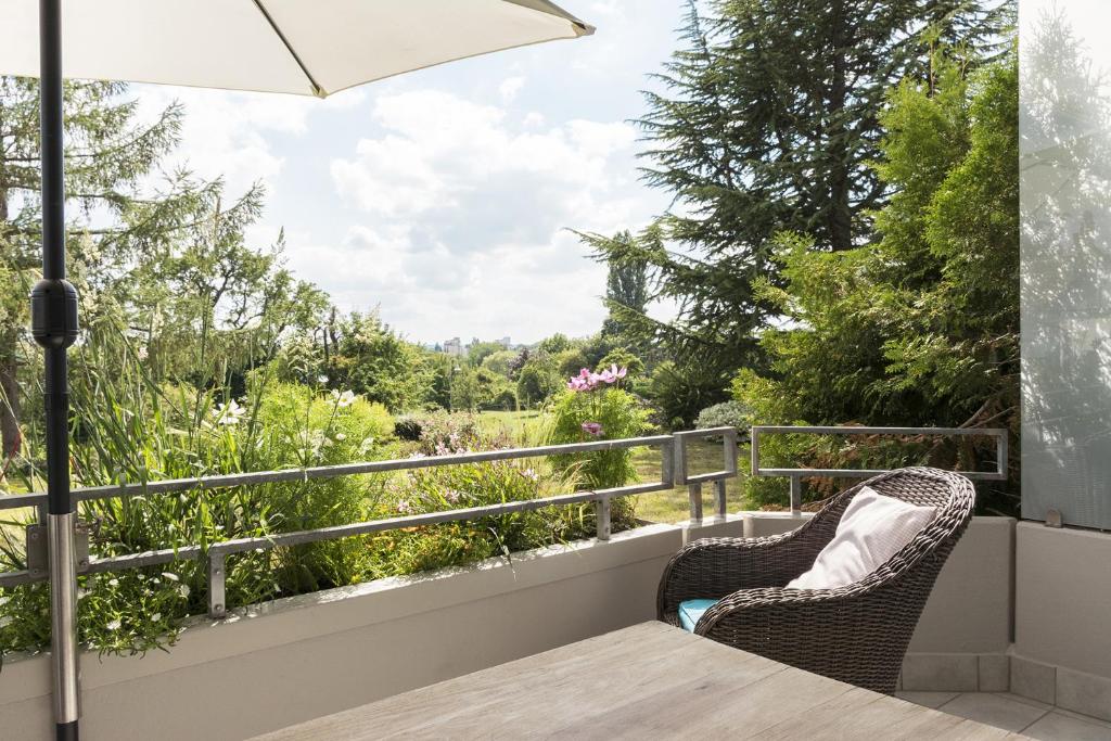 a balcony with two chairs and a view of a garden at Seesterne Comfort in Konstanz
