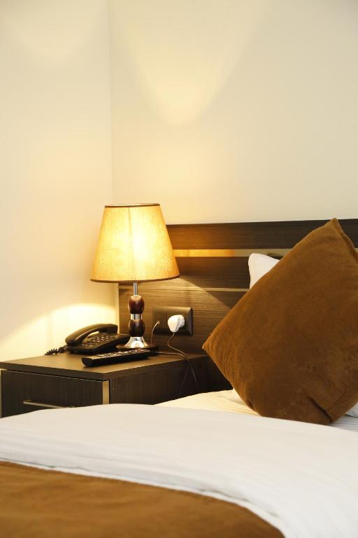 Postel nebo postele na pokoji v ubytování Tomu's Hotel