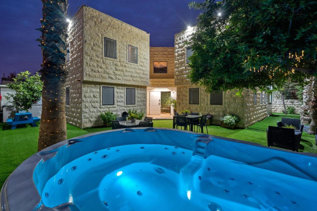 a backyard with a hot tub in front of a building at מלון לה פינקה - מלון סוויטות יוקרתי in Beer Sheva