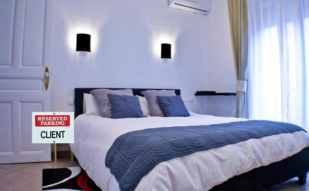 a bedroom with a large bed with blue pillows at BéziersApart *** vivre à la française comme un habitant in Béziers