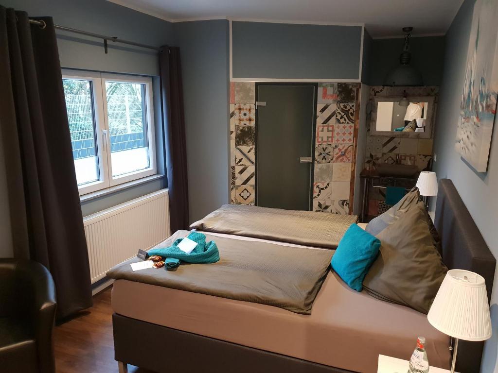 a small bedroom with a bed with blue pillows at Hotel Nacht-Quartier in Willich