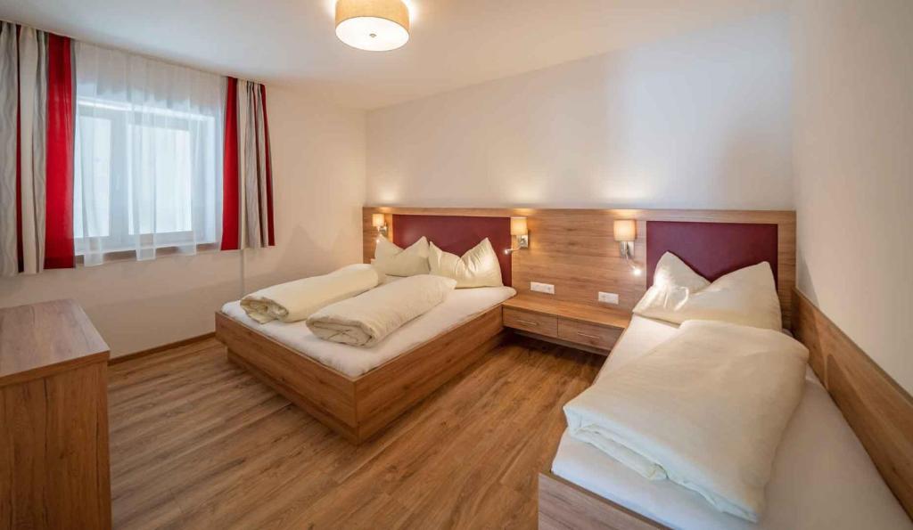 ein Hotelzimmer mit 2 Betten und einem Fenster in der Unterkunft Haus Schluder - Familie Stanitzer in Weissensee