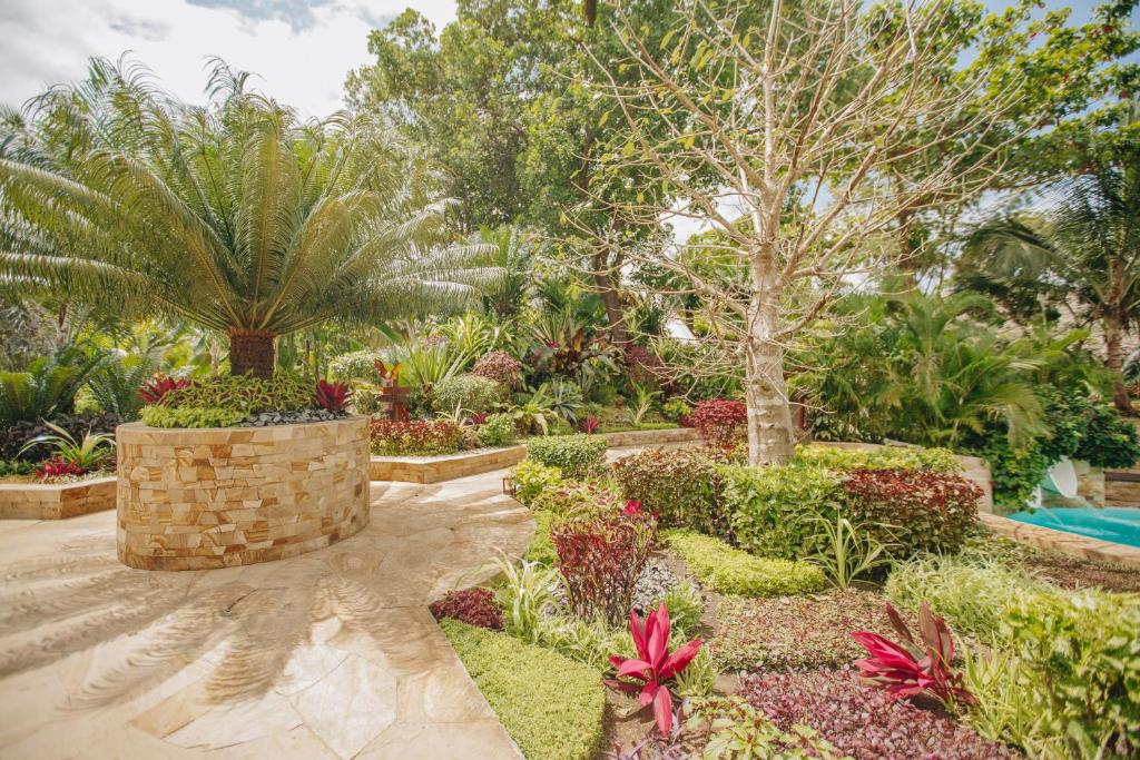 a garden with plants and trees and a pool at Tulia Zanzibar Unique Beach Resort in Pongwe