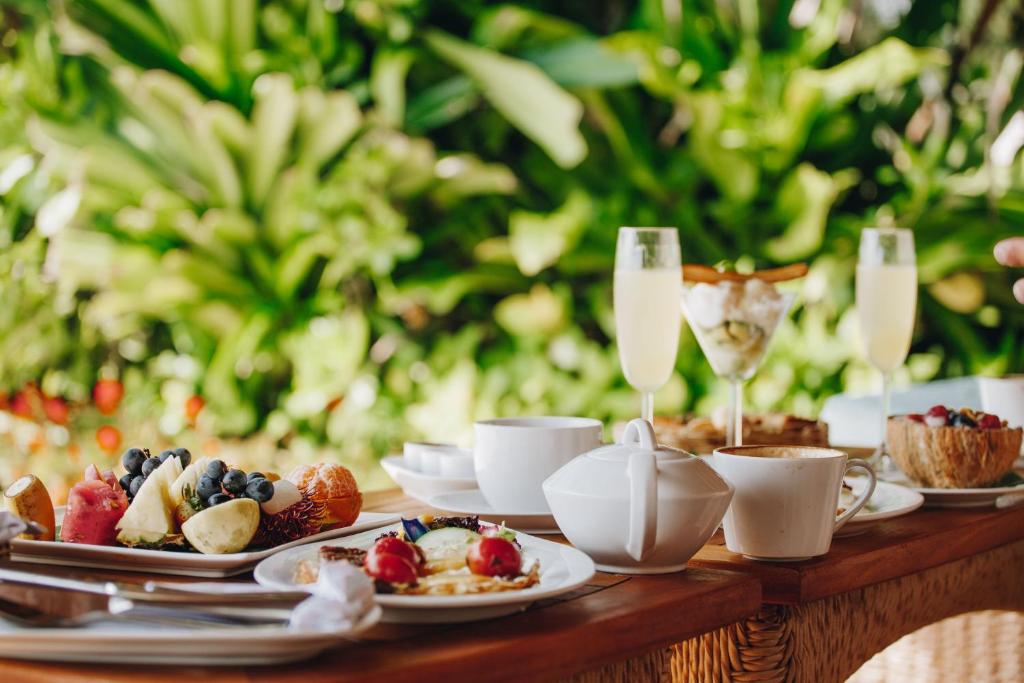 a table with plates of food and glasses of champagne at Tulia Zanzibar Unique Beach Resort in Pongwe