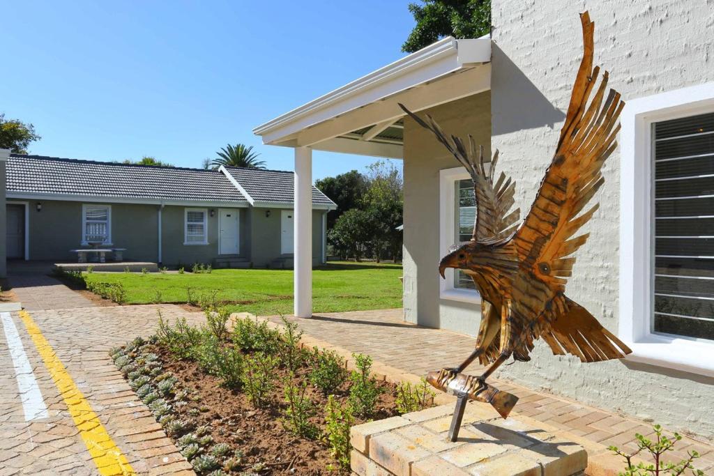 a metal bird statue in front of a house at Eagle Cove in Honeydew
