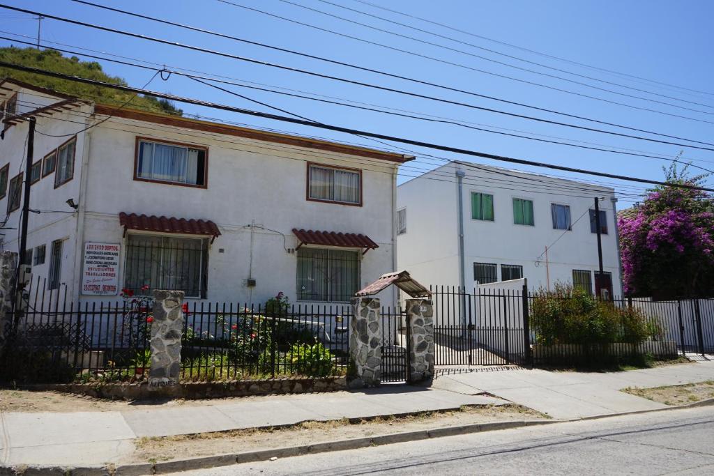 una casa blanca con una valla delante en Hostal Limonares, en Viña del Mar