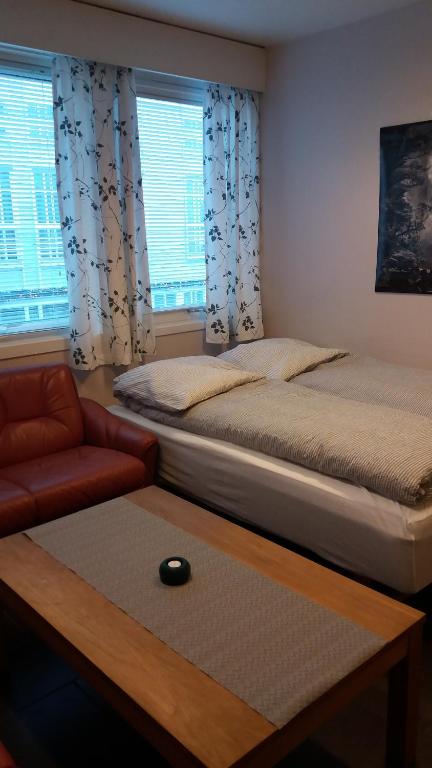 a bedroom with two beds and a couch and a table at Ekirom in Egersund