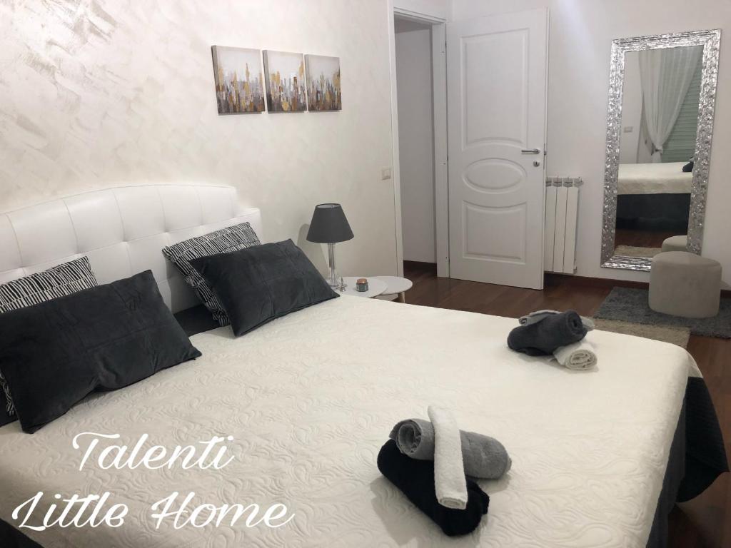 a bedroom with a white bed with towels on it at Talenti little home in Rome
