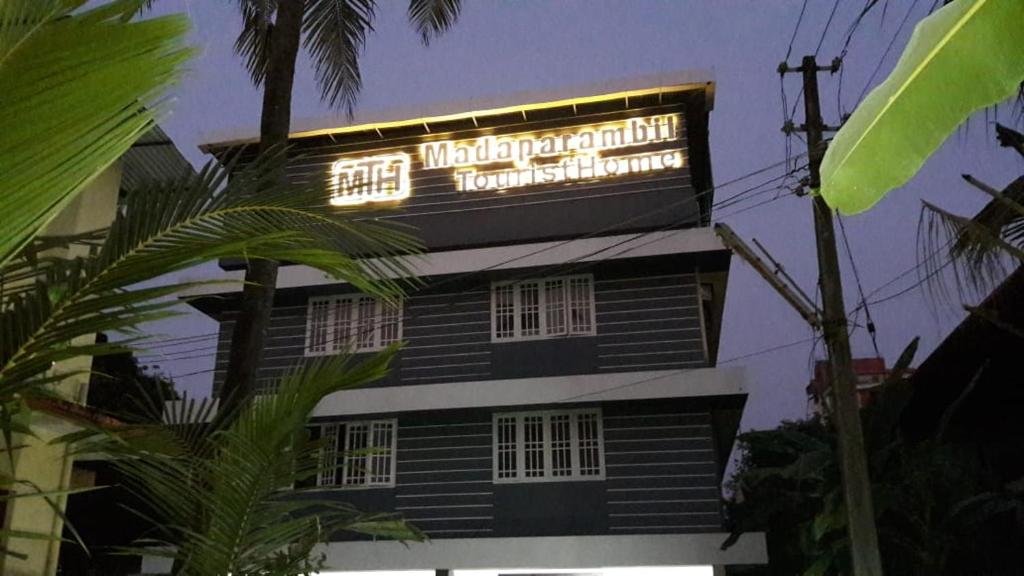 a building with a sign on the top of it at Madaparambil Tenants Home in Ernakulam