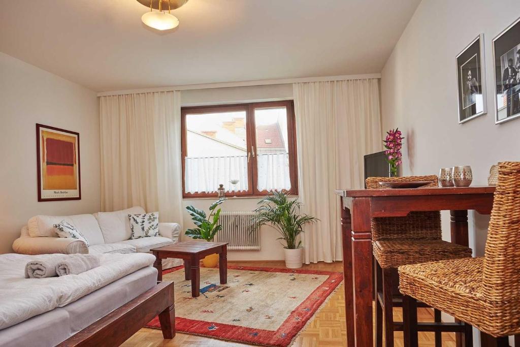 a living room with a couch and a table at Wohnen im Kolonialstil inklusive Tiefgarage, kontaktloser Check-in in Klagenfurt