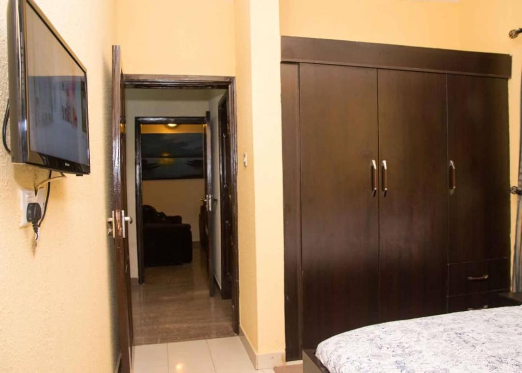 a bedroom with a bed and a flat screen tv at Casabella 2 BED VGC in Lekki