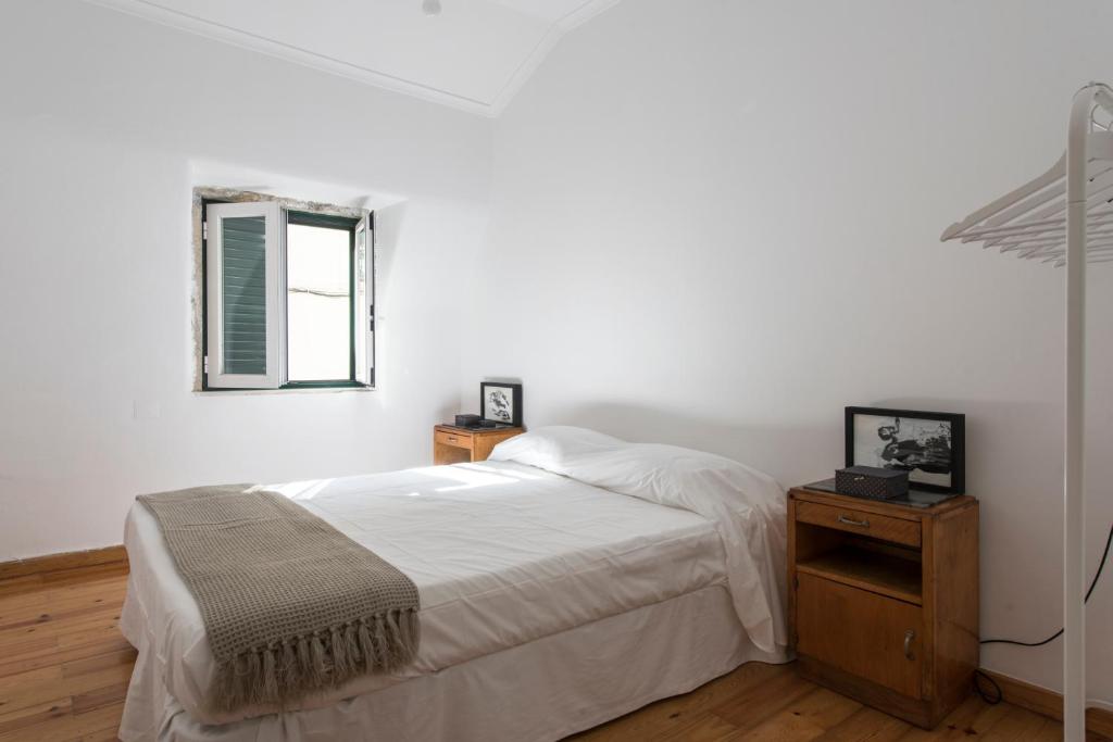 リスボンにあるCasa da Bombardaの白いベッドルーム(ベッド1台、窓付)