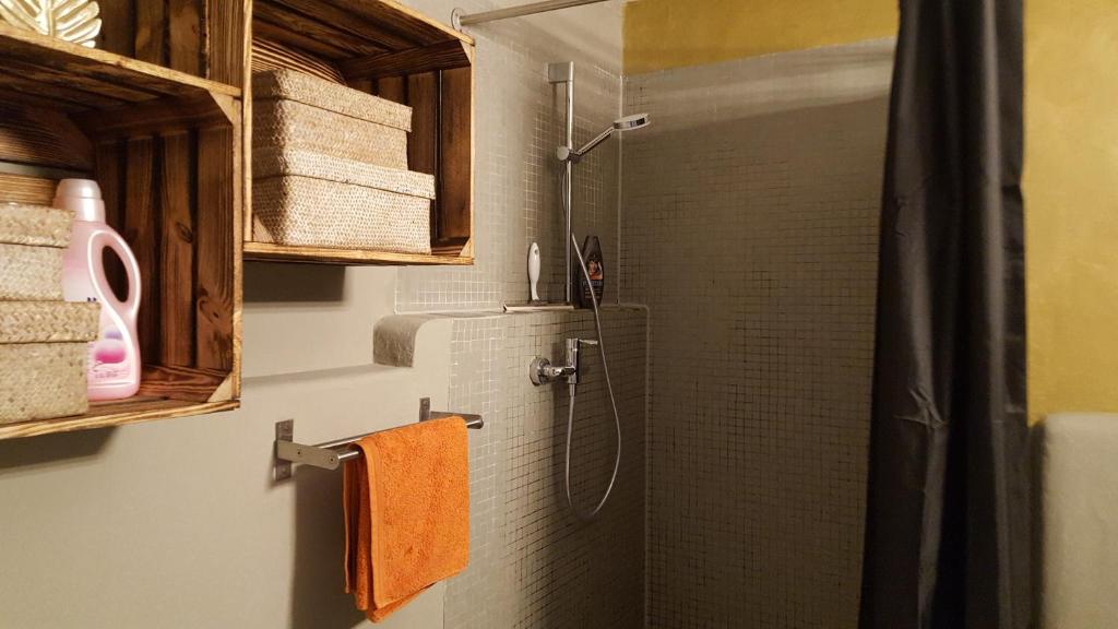 een badkamer met een douche en oranje handdoeken bij Appartement Baju in Bad Urach