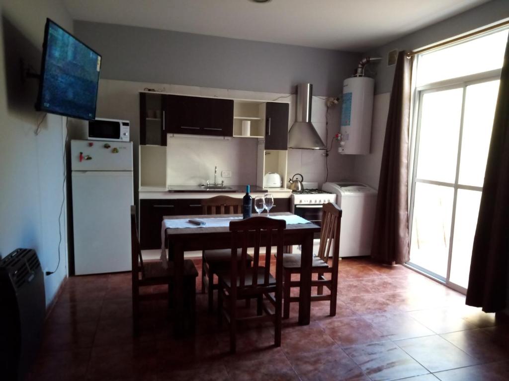 La cuisine est équipée d'une table, de chaises et d'un réfrigérateur. dans l'établissement Los Nietos Alojamientos, à Mendoza