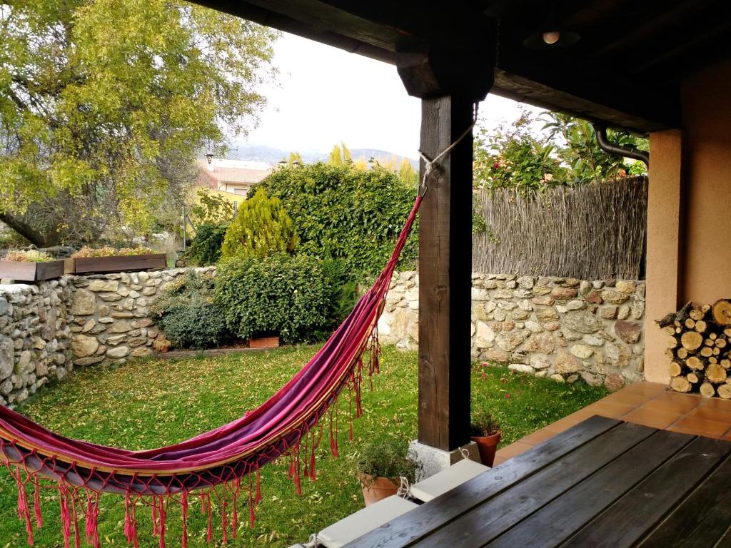 a hammock in a garden with a stone wall at La Majada de Alameda in Alameda del Valle