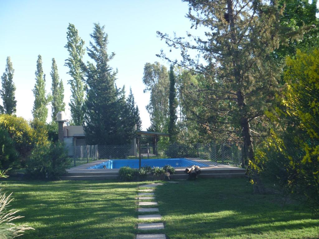 a yard with a swimming pool and trees and grass at Cabañas Aike in San Rafael