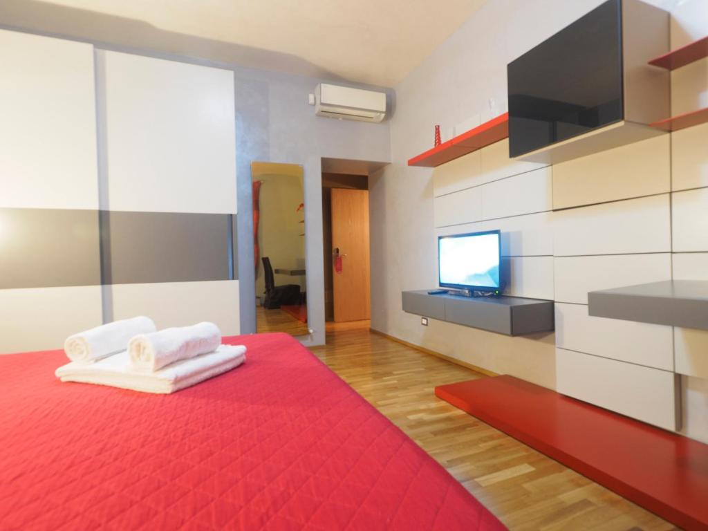 Habitación con cama roja y TV en la pared. en St. Peter Luxury Inn, en Roma