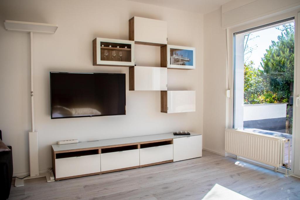 ein Wohnzimmer mit einem Flachbild-TV an der Wand in der Unterkunft Liebesvolles Studio in Eppstein in Eppstein