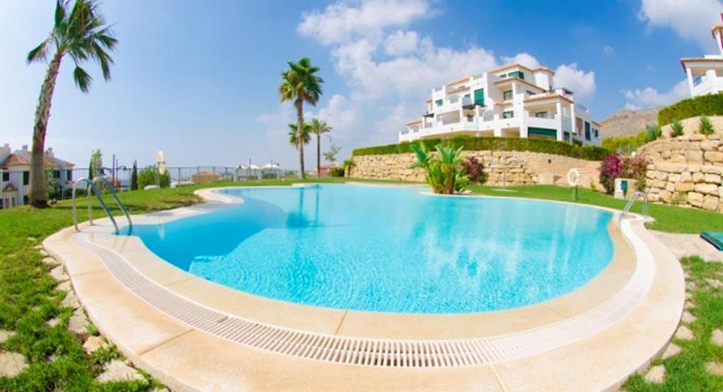 una piscina con una casa en el fondo en Balcon de Sierra Cortina! Panoramic sea view !, en Finestrat