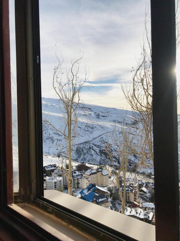 una ventana con vistas a una ciudad nevada en SuperB Apartment Sierra Nevada, en Sierra Nevada