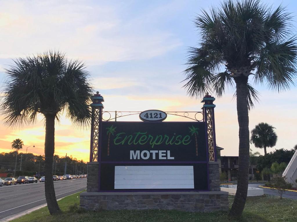 a sign for a motel with two palm trees at Enterprise Motel in Kissimmee