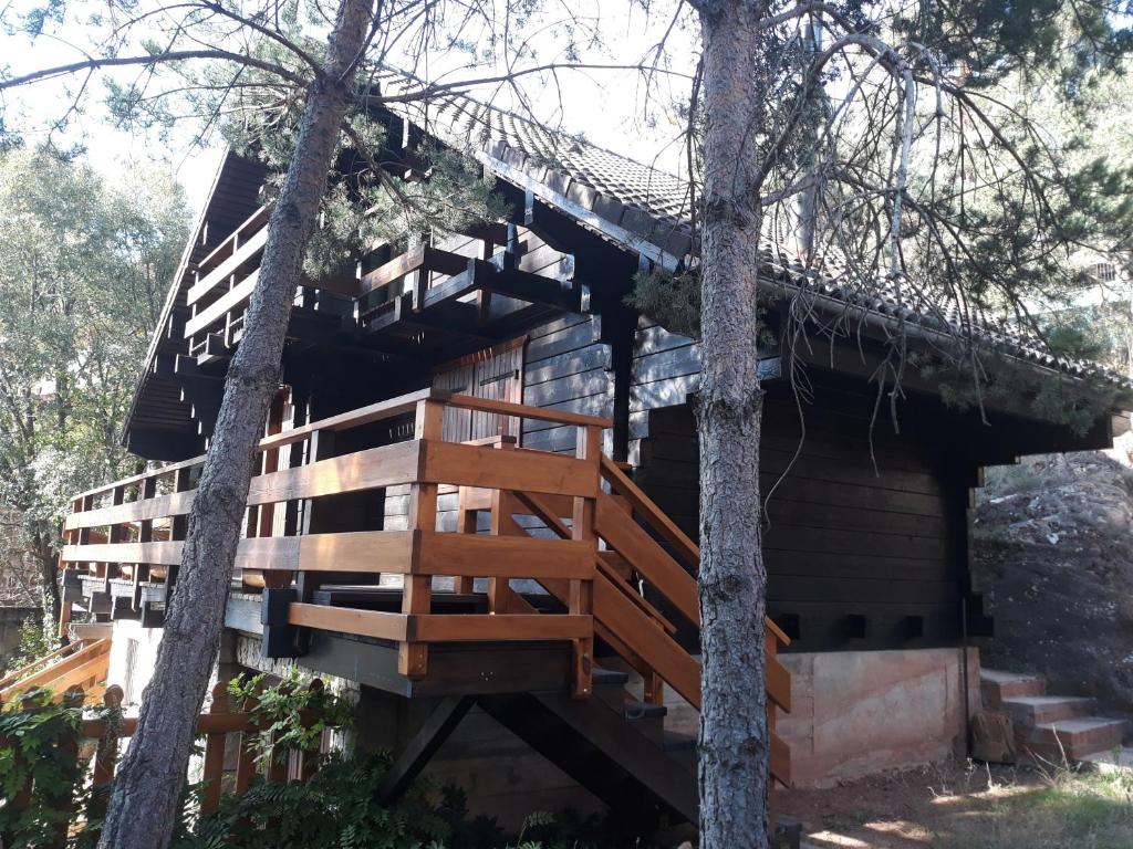 a tree house with a deck and stairs at Cañon del río Lobos-La cabaña de Ton in San Leonardo de Yagüe