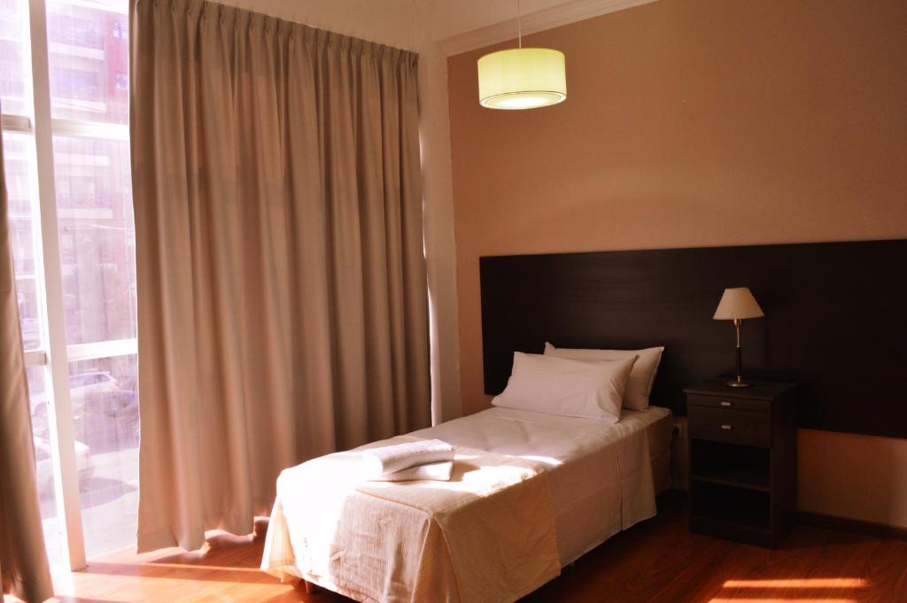 a bedroom with a bed and a large window at 770Hotel in Mar del Plata