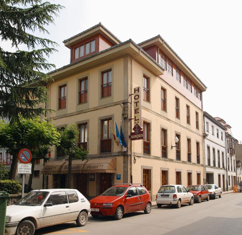 un grupo de coches estacionados frente a un edificio en Hotel Restaurante El Manquin, en Villaviciosa