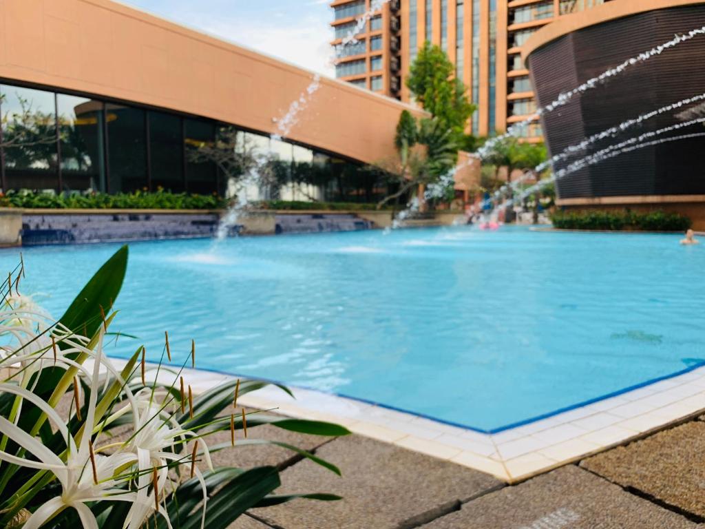 einem großen Pool mit einem Brunnen vor einem Gebäude in der Unterkunft KL Service Suites at Times Square KL in Kuala Lumpur