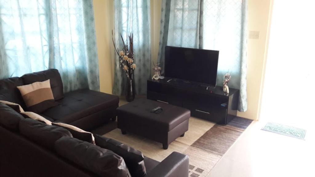 a living room with a couch and a flat screen tv at Wilks Villa in Knowles