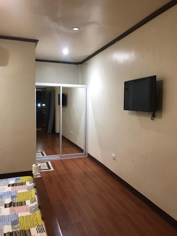 a living room with a flat screen tv on the wall at Hadassah’s Place in Olango Island
