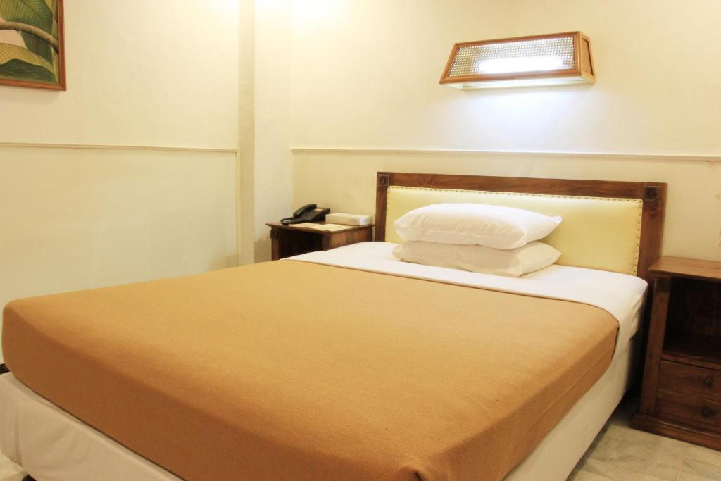Postel nebo postele na pokoji v ubytování Hotel Karthi Kuta