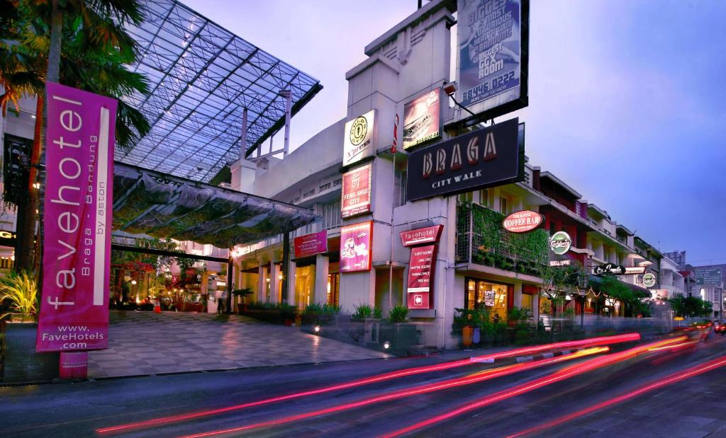 uma rua da cidade com edifícios e placas de néon à noite em favehotel Braga em Bandung