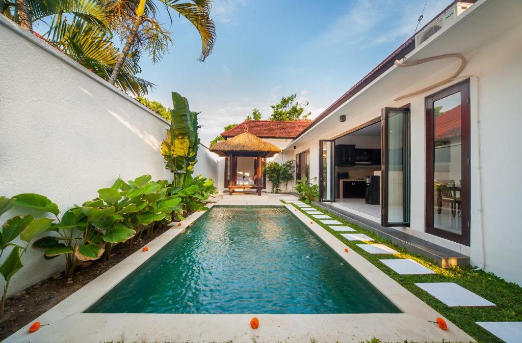 una imagen de una piscina frente a una casa en Clover Villa Sanur, en Sanur