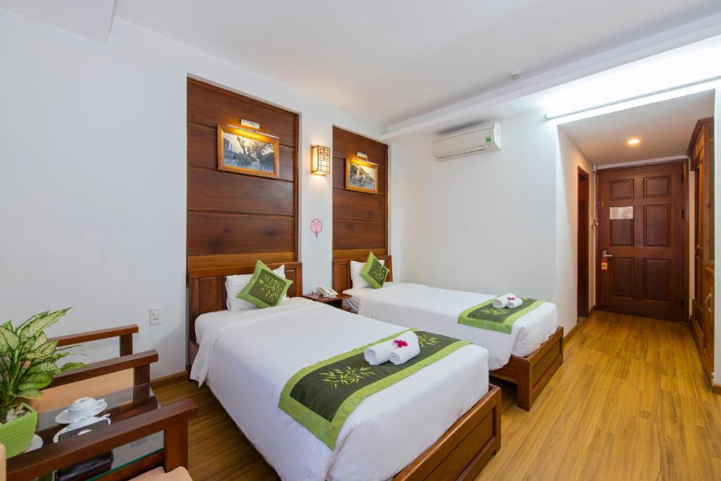Postel nebo postele na pokoji v ubytování Kiman Hoi An Hotel