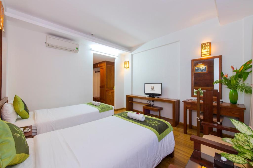 Postel nebo postele na pokoji v ubytování Kiman Hoi An Hotel