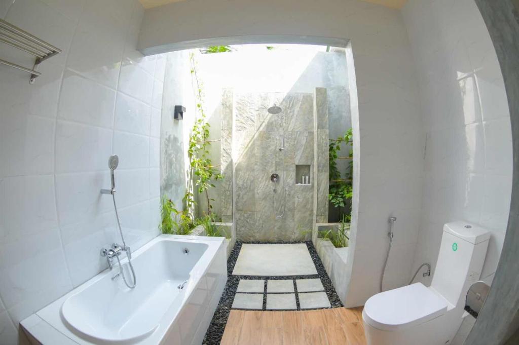 a bathroom with a shower and a tub and a toilet at Tiger Shark Residence & Dive in Fuvahmulah