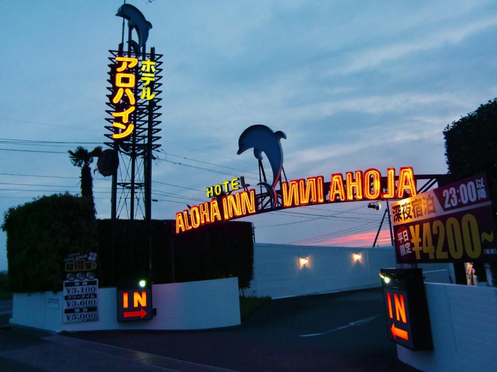 a neon sign with a dolphin on top of it at Alohain Yonago in Yonago