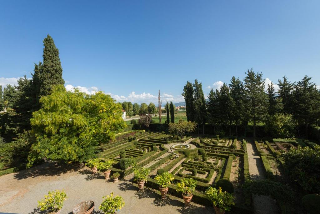 3bdrm luxury Apartment in Tuscan Villa,Private Estate, shared Swimmingpool في فلورنسا: إطلالة علوية على حديقة بها نباتات وأشجار