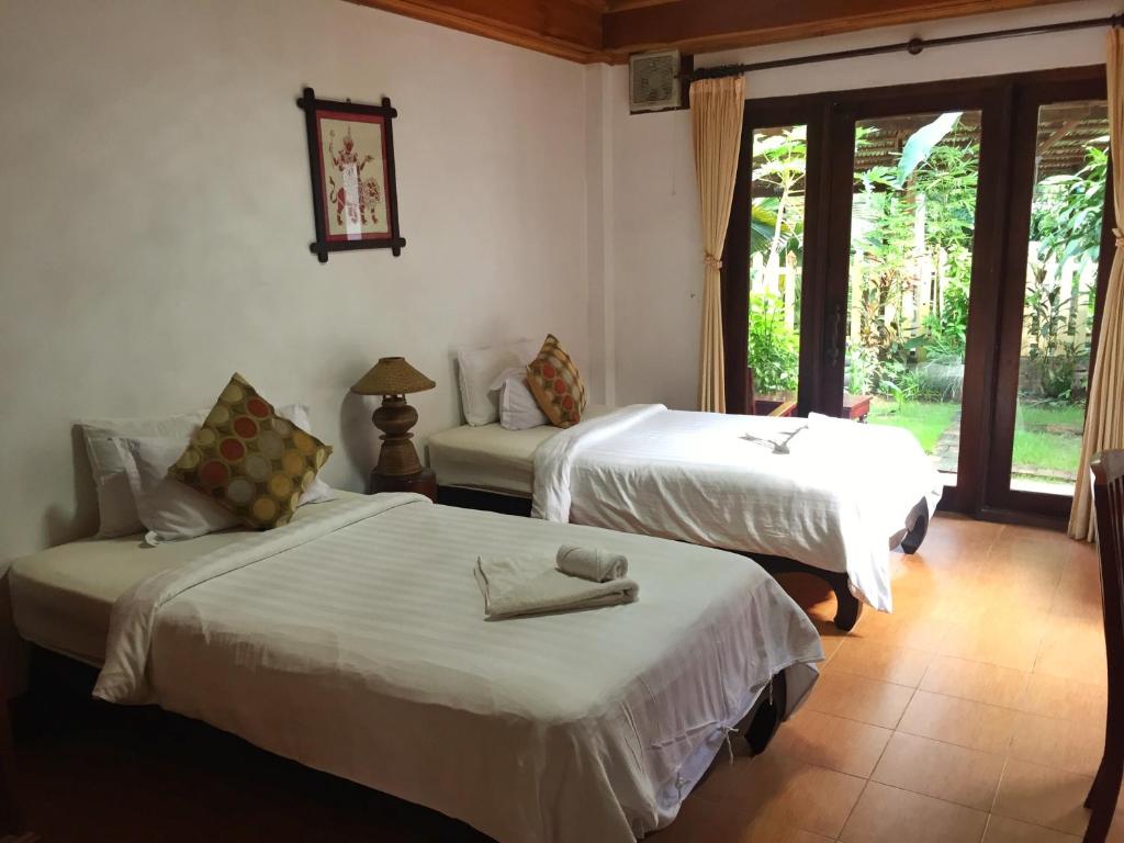 - 2 lits dans une chambre avec fenêtre dans l'établissement Villa Sayada, à Luang Prabang