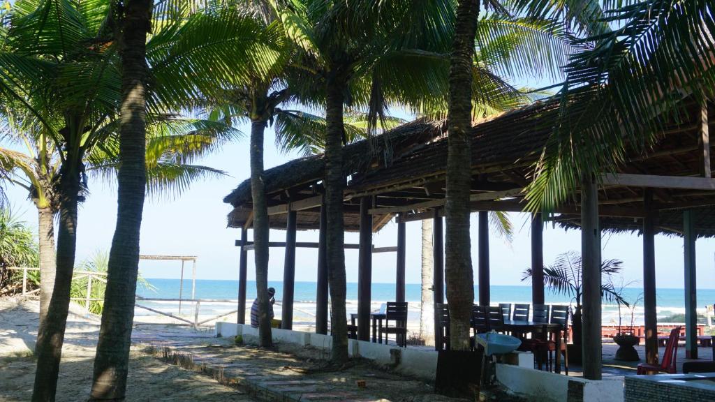 a building on the beach with palm trees at Tam Thanh Natural Beach Resort in Tam Kỳ