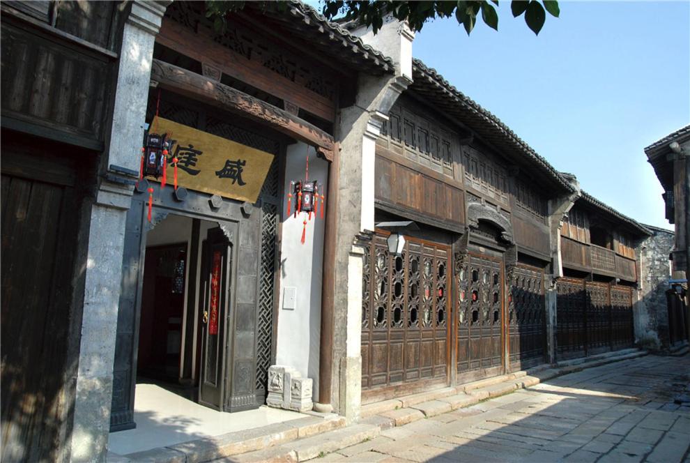 a building with wooden doors on a street at Wuzhen Clubhouse (In Xizha Scenic Area - ticket included) in Tongxiang