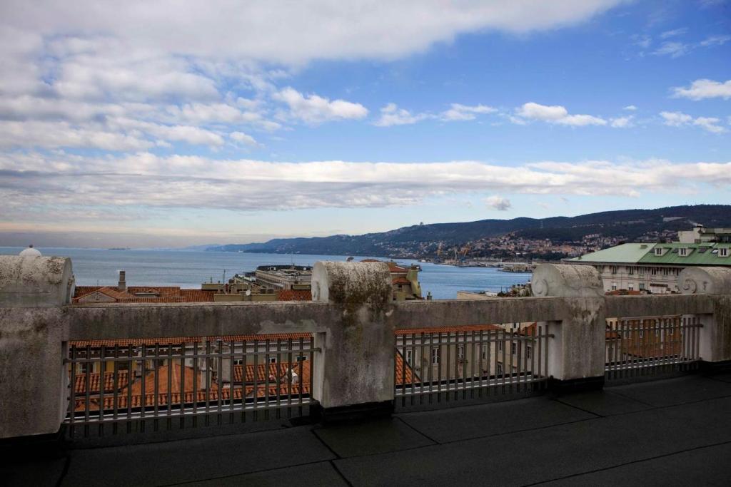 a balcony with a view of the ocean and a city at Residence Liberty in Trieste