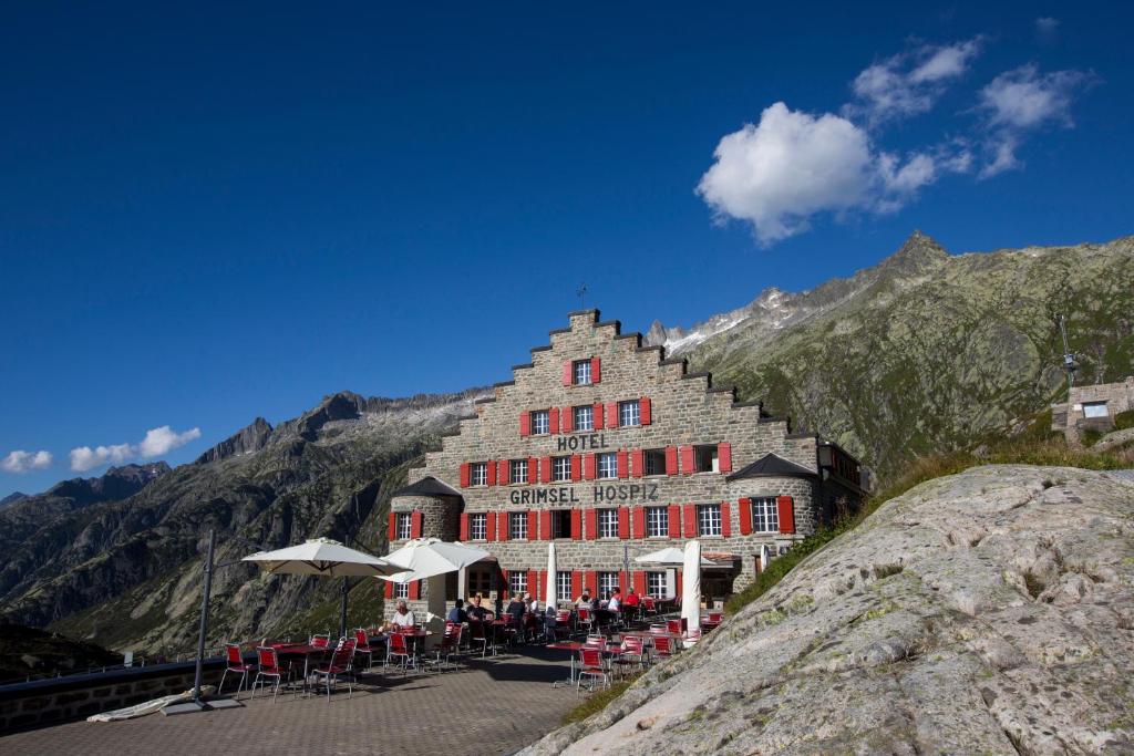 um grande edifício ao lado de uma montanha em Historisches Alpinhotel Grimsel Hospiz em Grimsel Hospiz